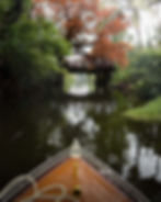 Small boat on a river under a bridge, photography portfolio.