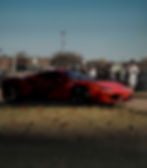 Red Ferrari at an outdoor photography portfolio showcase.