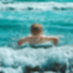 Young boy swimming in ocean waves, photography portfolio