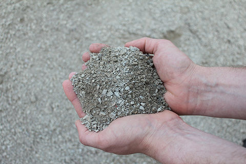 Hände halten feinen Splitt 0-5