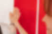 Zwei Frauen klatschen mit ihren Händen ein vor einem rot-weißen Hintergrund.