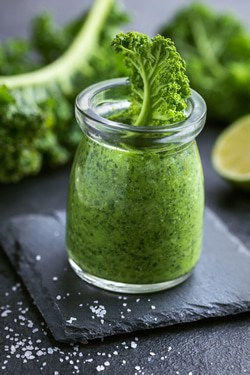 kale presto sauce with raw leaf in jar
