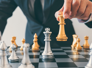 business man leaning over chess table moving pawn