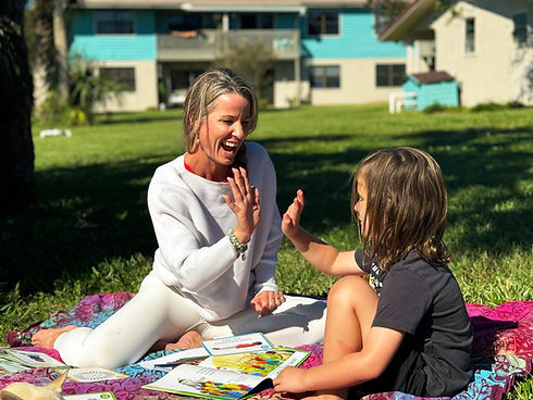 Caitlin Mason sitting outside, working with a child during a speech therapy session