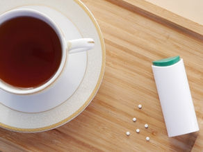 Cup of tea on a try with a tube of artificial sweetener next to it.