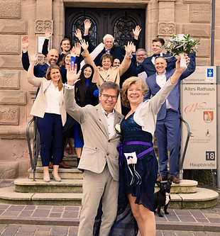 Fröhliche Hochzeitsgesellschaft vor dem Alten Rathaus nach einer standesamtlichen Trauung.