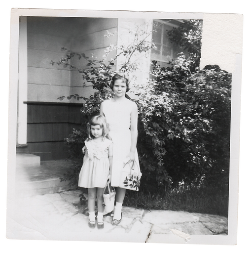 Two sisters in the 1950s posing outside the front door of their home, dressed for Easter Sunday