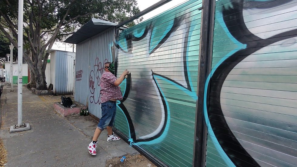 Un hombre haciendo graffiti en la calle