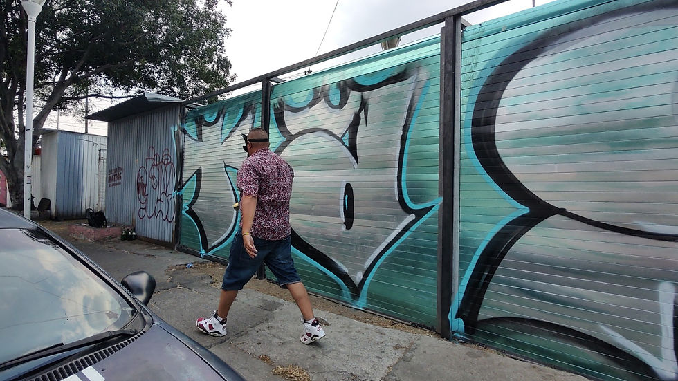 Un hombre haciendo graffiti en la calle.