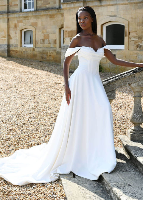 Dando, Swinton is an elegant ivory crepe A-line wedding dress features a strapless boned bodice with a pleated and beaded crumb-catcher neckline for a sophisticated touch. Crepe buttons cascade all the way down the back, completing the look with timeless detail. The detachable crepe Bardot sleeves add versatility, allowing for a stunning transformation from ceremony to reception.
Neckline Sweetheart
Fabric Crepe
Sleeve Style Detachable