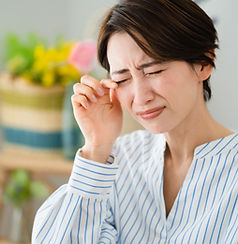 目をこする女性