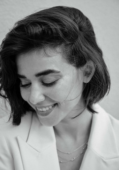 das braunhaarige Model Hila schaut lächelnd zur Seite