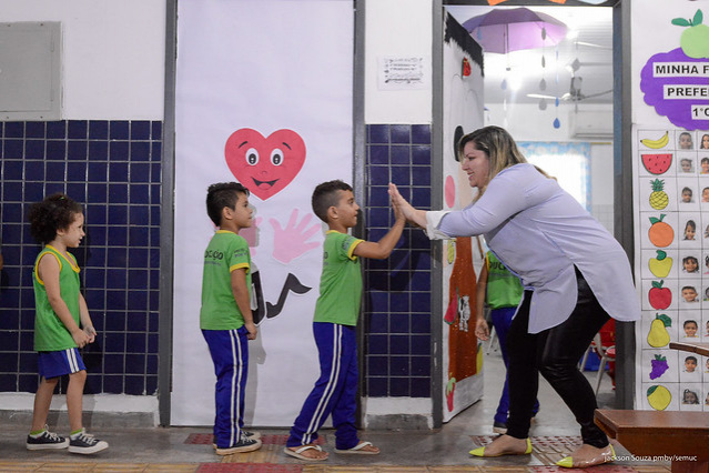 Professora recebendo os alunos na Sala - Escola Pública