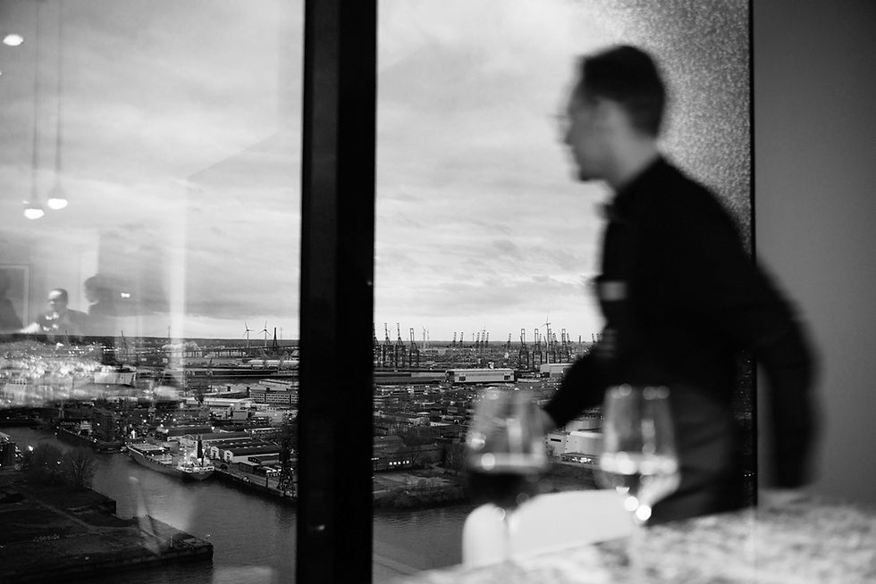 Urbane Porträtfotografie Hamburg: Unscharfer Mann vor Hafenpanorama