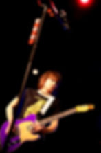 Konzertfoto der Sängerin Chrissie Hynde in poppigen farben vor schwarzem hintergrund mit gitarre