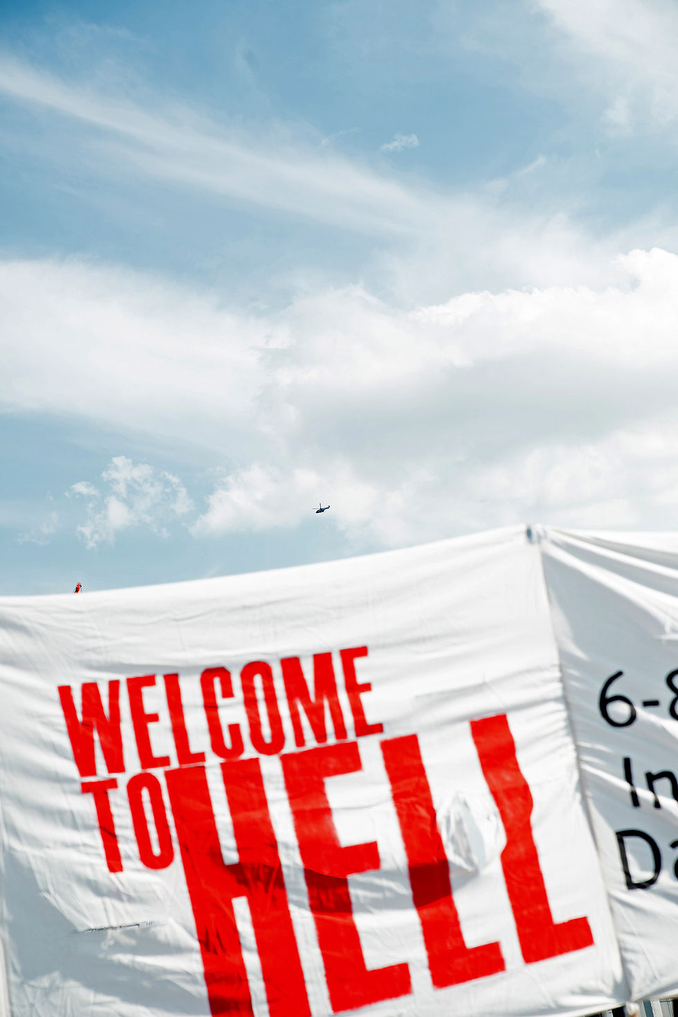 Welcome to hell auf einem Banner vor blauem Himmel