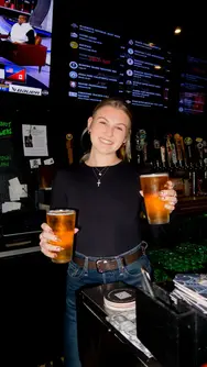Bartender from Lokul Jamul Tap and Grill serving two beers to customer