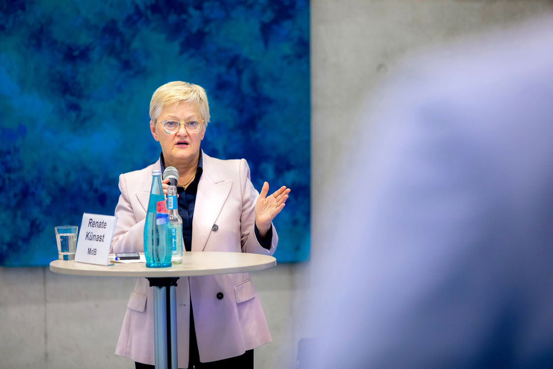 Renate Künast bei einer Veranstaltung in Berlin im intensiven Dialog am Stehtisch mit Mikrofon – dokumentiert durch professionelle Eventfotografie für Konferenzen und Diskussionsformate.