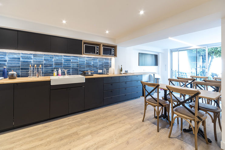 Restructuration d'un espace d'accueil et de salles de réunion par AMCD, architecte d'intérieur. Création d'un réfectoire pour les salariés. Faïence MARAZZI LUMÉ, chaises MAISON DU MONDE, cuisine IKEA et plan de travail en chêne sur mesure, tables sur mesure avec pied bistrot. FIFTY BEES. 