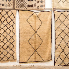 Three beige Moroccan rugs with geometric patterns