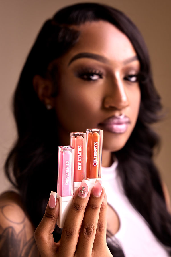 A close up of three Kodie Cosmetics bottles in a woman's hand