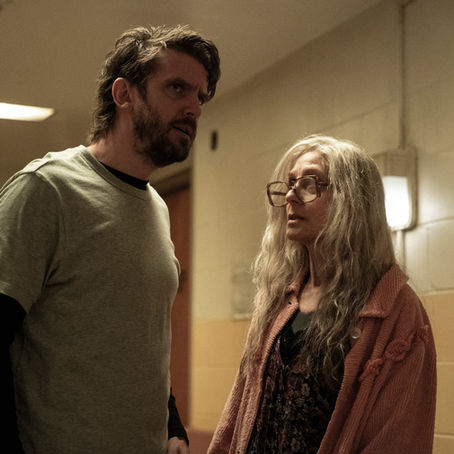 Dan Stevens standing inside a dark, deteriorating psychiatric hospital in The Terror: Devil in Silver