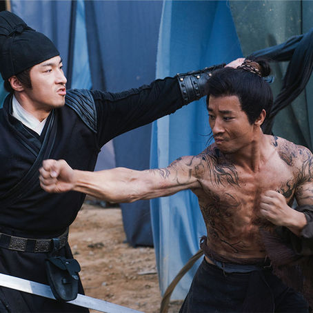 A warrior holds a sword in a tense wuxia battle scene.