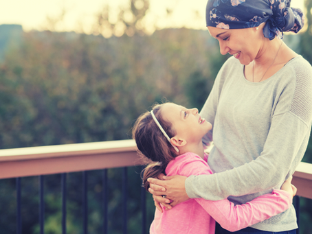 a mother with cancer hugs her young daughter