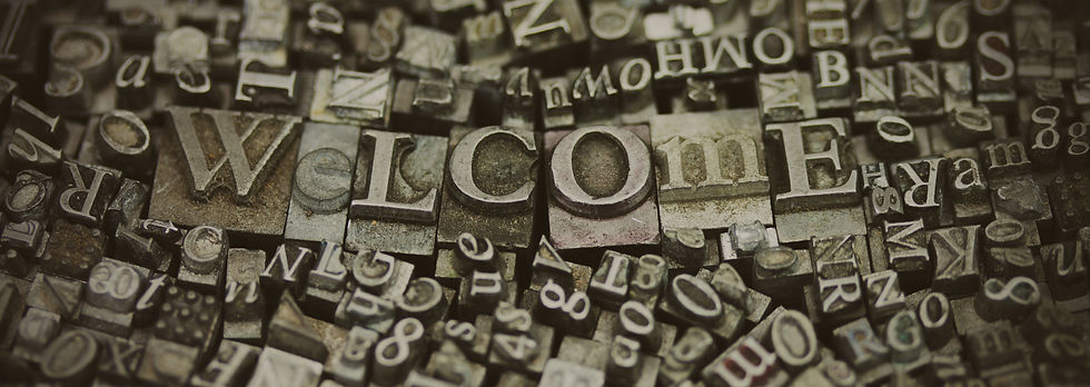 Printing press letter tiles spelling out "Welcome"
