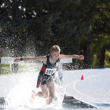 Athlete jumping in the water of Steeplechase