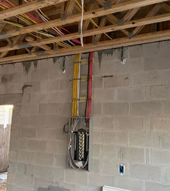 Color-coded Romex cables being installed on a new construction electrical panel in Clearwater, FL – residential electrical wiring