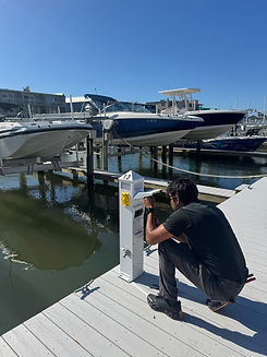 Luis, master electrician from Coastal Palms Electrical, inspecting a marina pedestal in Florida.