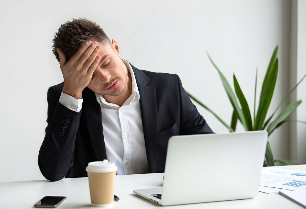 Un hombre con resaca trabaja en su oficina.