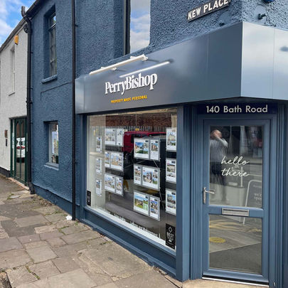 Professionally painted commercial property exterior with a Cheltenham estate agent's property cladding, door, door frame and window frames painted blue to match the signage colour.