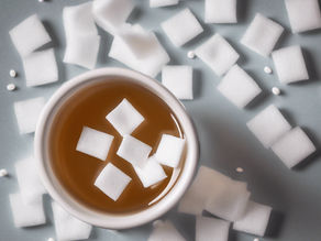 artificial sweeteners in a cup of tea with other sweeteners spread around