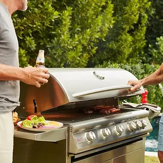 Elite Systems Experts technician performing outdoor BBQ grill repair and maintenance on a Weber grill in a Westchester, NY backyard—trusted service