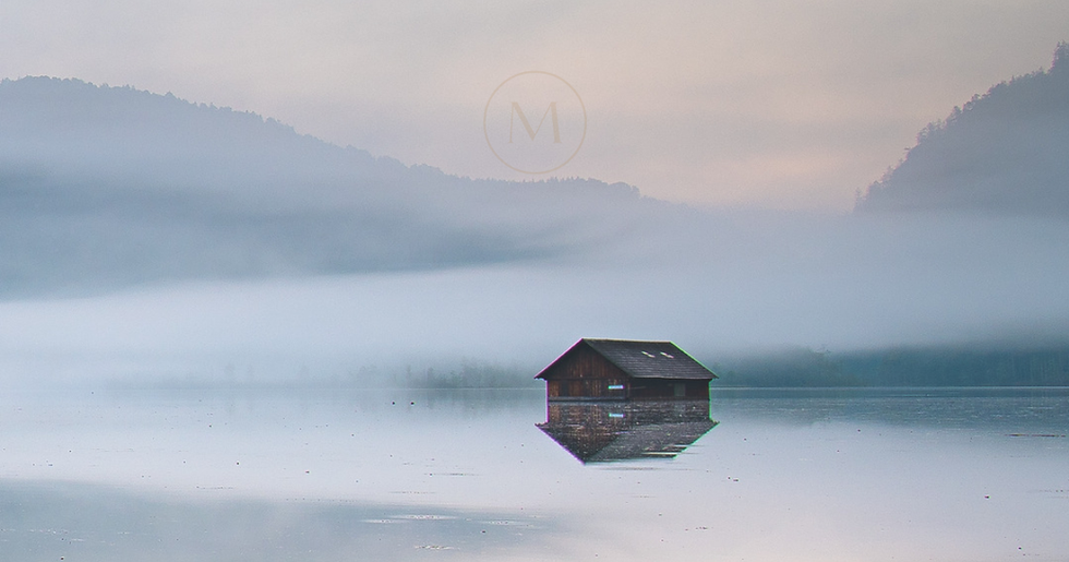 Mirna hiška na jezeru v jutranji megli kot simbol notranjega procesa, refleksije in postopne osebne preobrazbe.