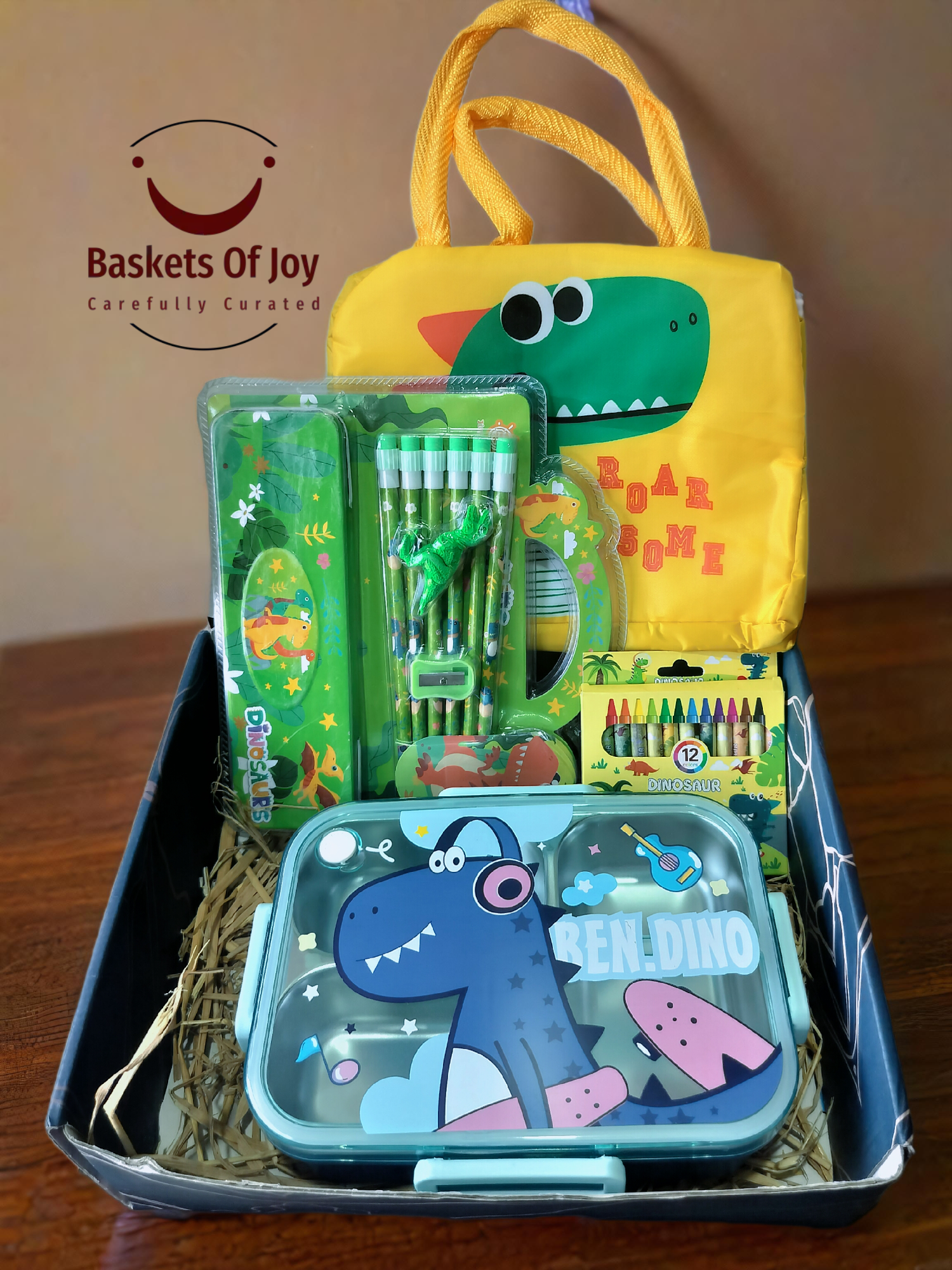 Dinosaur-themed kids' gift basket: stationery, lunchbox, bag