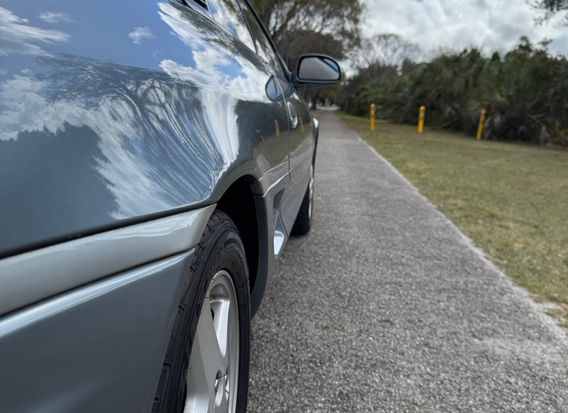 Side profile of 1995 Toyota MR2 G Limited Steel Mist Grey with alloy wheels and clean body lines.