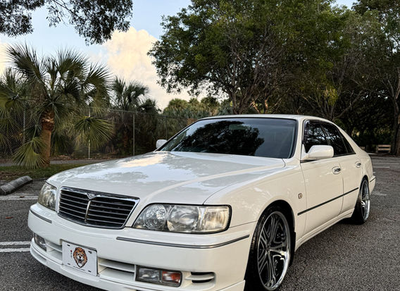 1997 Nissan Cima Turbo for sale at Lion JDM, showcasing a sophisticated black exterior, luxury sedan design, and powerful turbocharged engine. The car features sleek lines, premium alloy wheels, and a comfortable, well-appointed interior. Available for purchase, this rare model combines performance and elegance, making it a standout choice for collectors and driving enthusiasts.