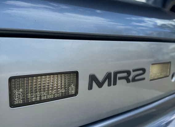 Rear view of 1995 Toyota MR2 G Limited in Steel Mist Grey with factory spoiler and clean taillights.