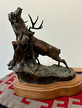 bronze sculpture by Jeff Wolf of a deer scratching his back on a tree at Gold river gallery