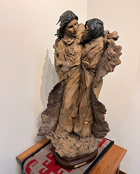 Sculpture by Jeff Wolf of a man and woman wrapped up in a blanket at Gold River Gallery