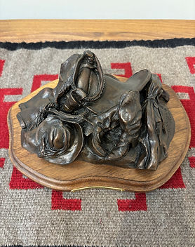 Bronze sculpture by Jeff Wolf of a cowboy who left all of his riding gear and clothes in a pile to go swimming 