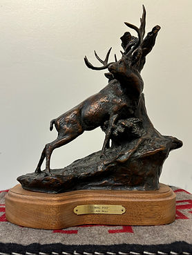 bronze sculpture by Jeff Wolf of a deer scratching his back on a tree at Gold river gallery