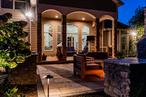 Landscape lighting highlights stone accents on home to extend into an outdoor living space that can be enjoyed throughout the seasons