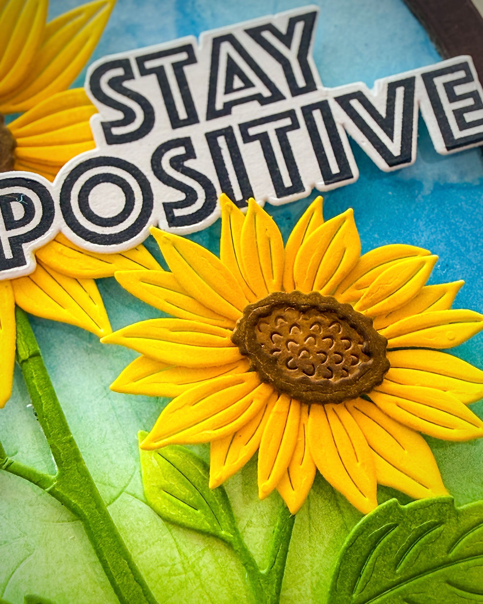 Yellow sunflower craft with green leaves and bold STAY POSITIVE text on a blue background