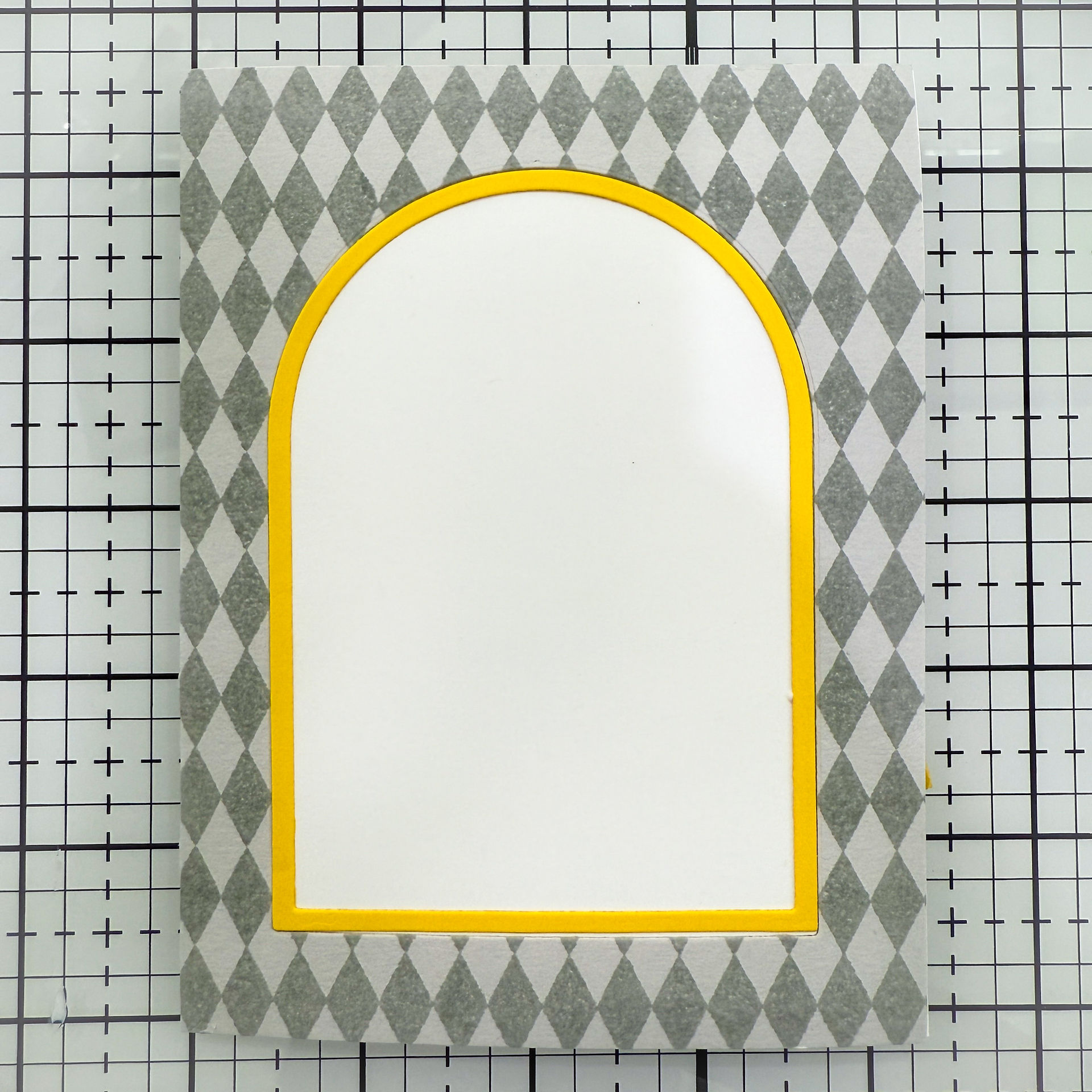 Pepita background and yellow frame on white card base.