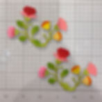 Colorful flower stickers on a grid surface with visible numbers. Flowers in pink, red, yellow, orange, and green create a vibrant look.