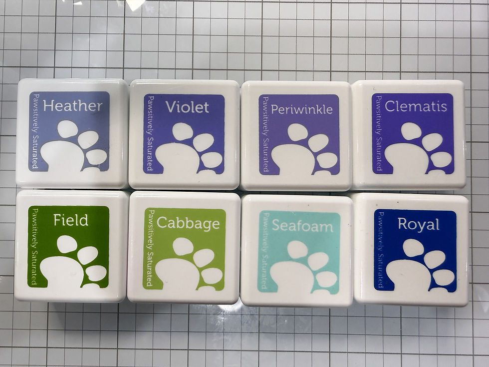 Eight color swatch tiles on a grid surface, labeled Heather, Violet, Periwinkle, Clematis, Field, Cabbage, Seafoam, and Royal.